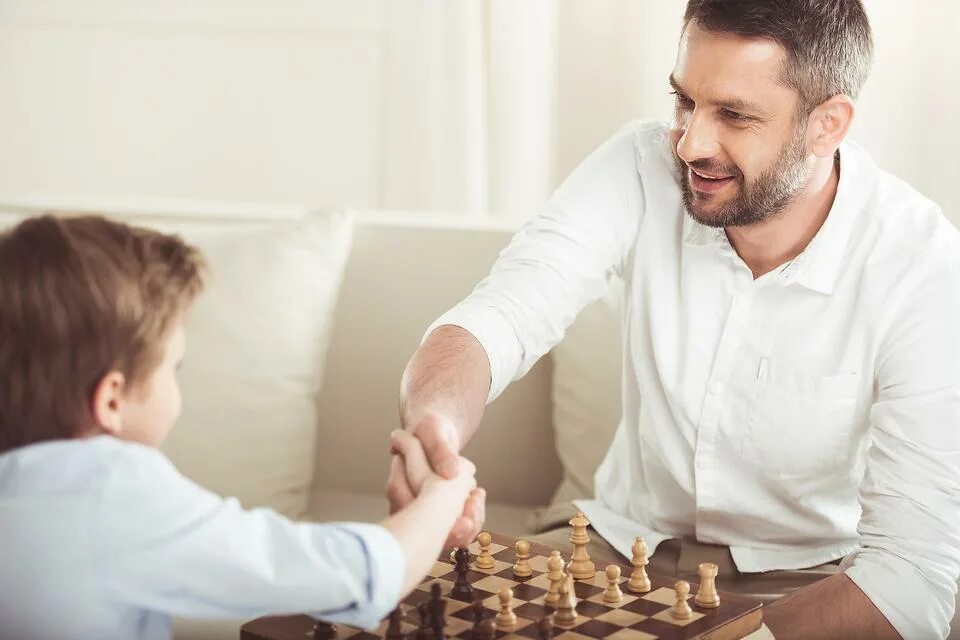 Папа играет в шахматы. Игра в шахматы отец и сын. Папа с сыном играют в шахматы. Шахматы дети и взрослые. Реклама отец и сын