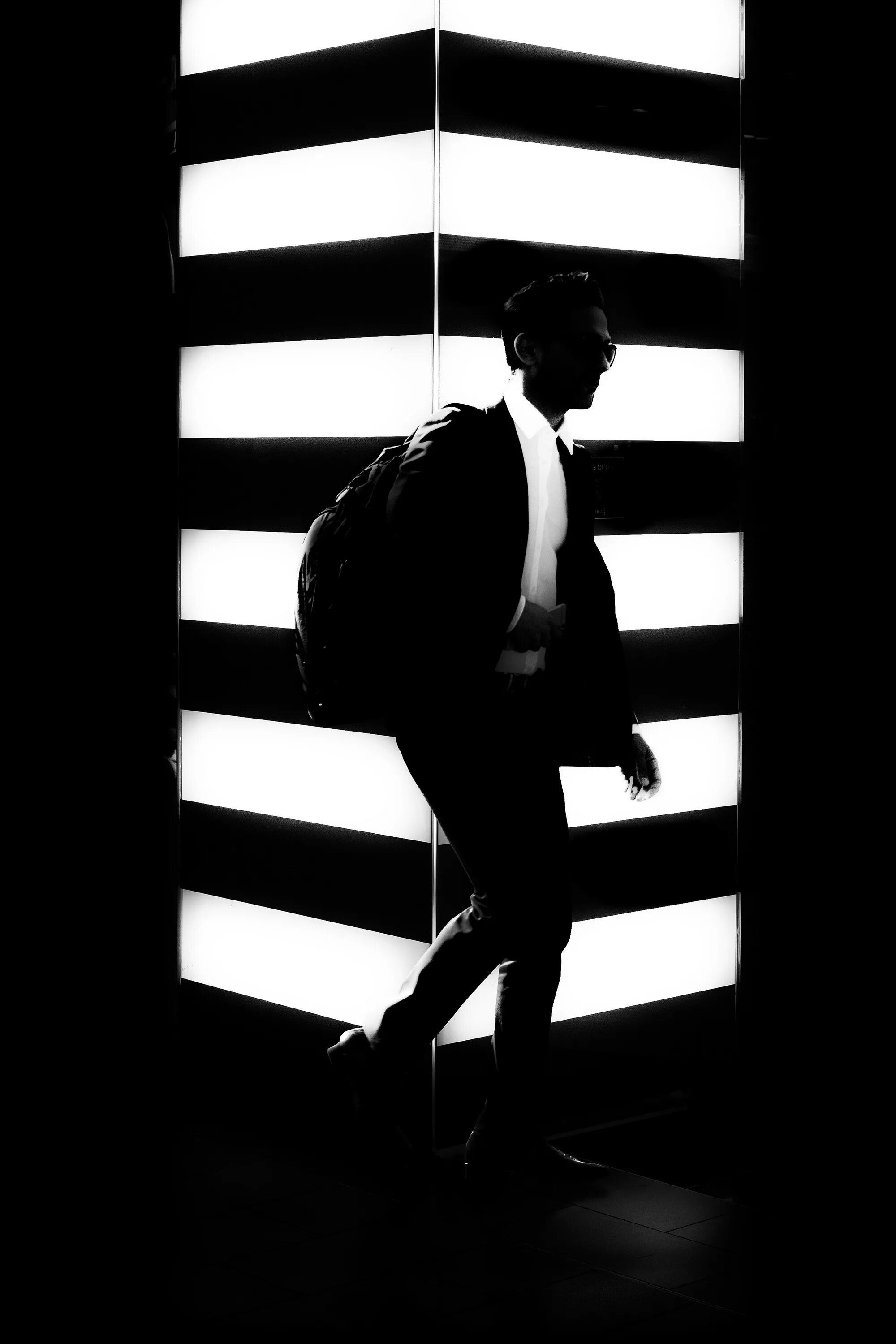 Standing shadows. Человек стоит в тени. Силуэт парня фото черно белое. Мужчина спиной с телефоном в темноте чб. Силуэт мужчины в черном цвете фото.