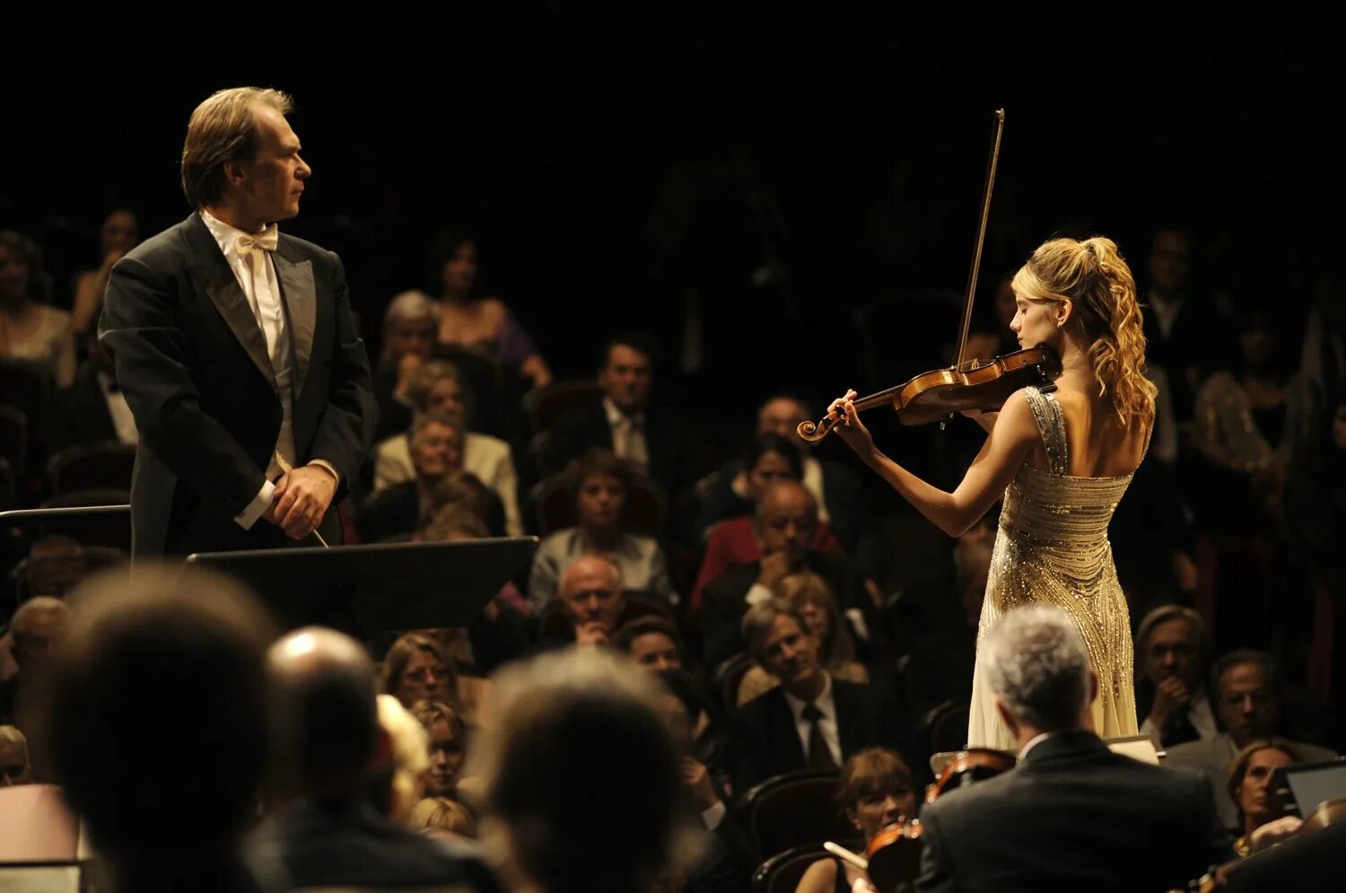 Концерты скрипачки. Melanie Laurent. Концерт (2009). Зрители на концерте классической музыки. Музыкант на сцене и зрители.