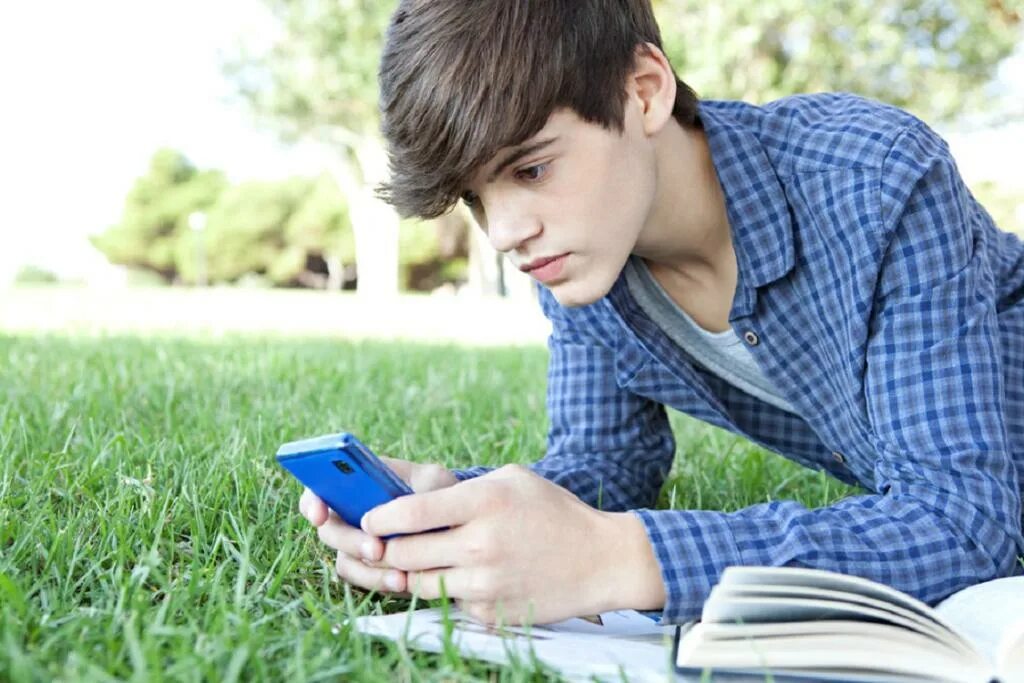 Выбрать телефон подростку. Подросток со смартфоном. Выбрать телефон подростку. Детский смартфон. Подросток сидит в телефоне.