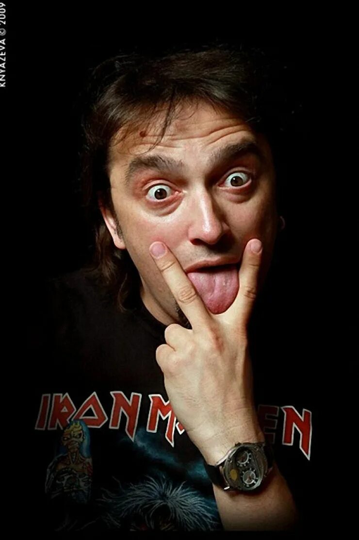 Парень показывает язык между пальцев. Неприличные жесты. Бородатый парень. Язык между двумя пальцами. Селфи с двумя пальцами.