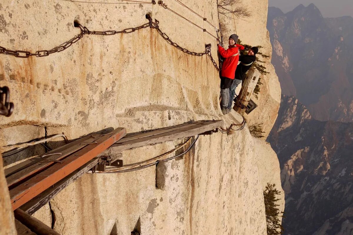 Мост над пропастью. Трос над пропастью. Самая опасная пешая тропа в мире на горе хуашань. Скалолазание на скалах. Канат между скалами.