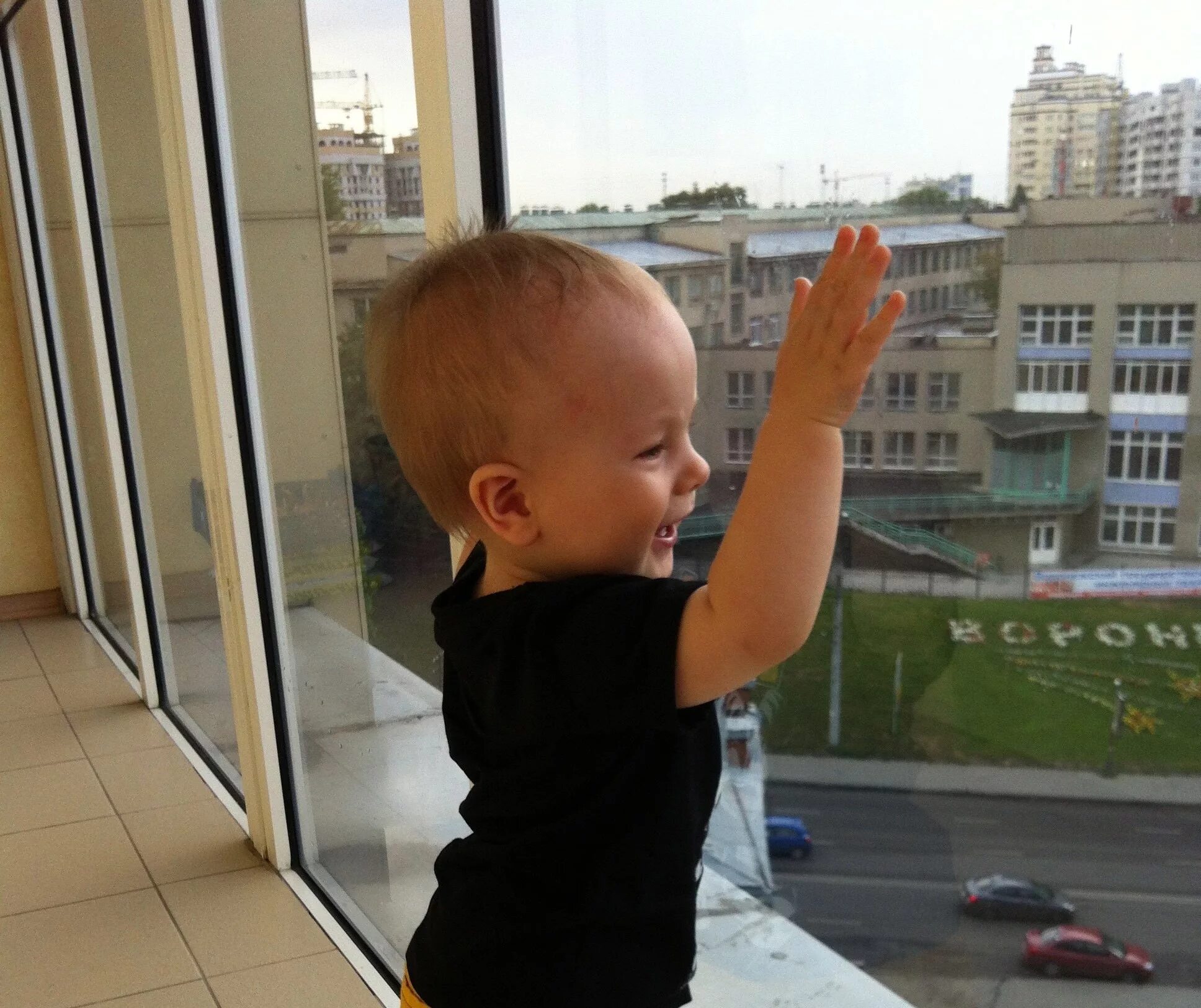 В окно весело играя. Ребенок у окна. Ребенок на балконе. Мальчик на балконе. Малыш у окна.