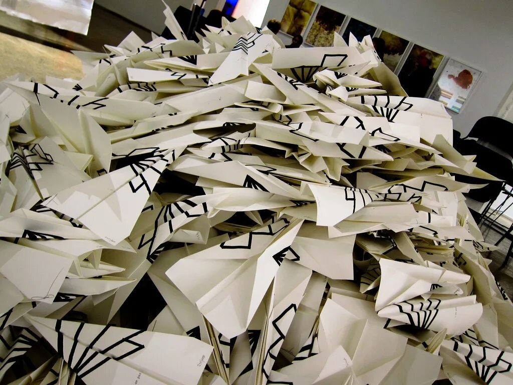 Много бумаги. Много бумажных. Музей бумажных самолетиков. Стопка бумаг на столе. Много бумажных.
