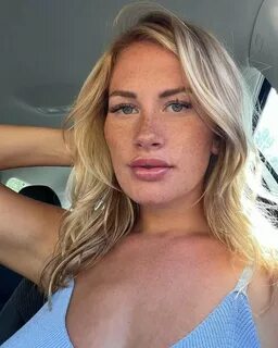Makayla Halstead is wearing sky blue dress and sitting in the car while pos...