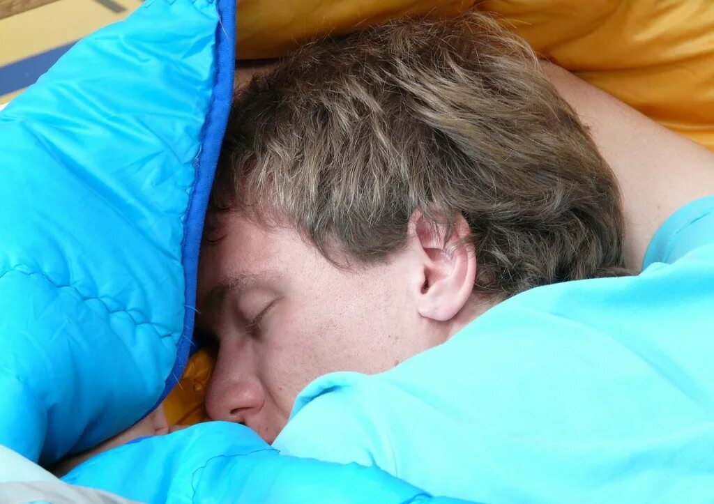 Парни спят в спальных мешках. Фото сонного человека.