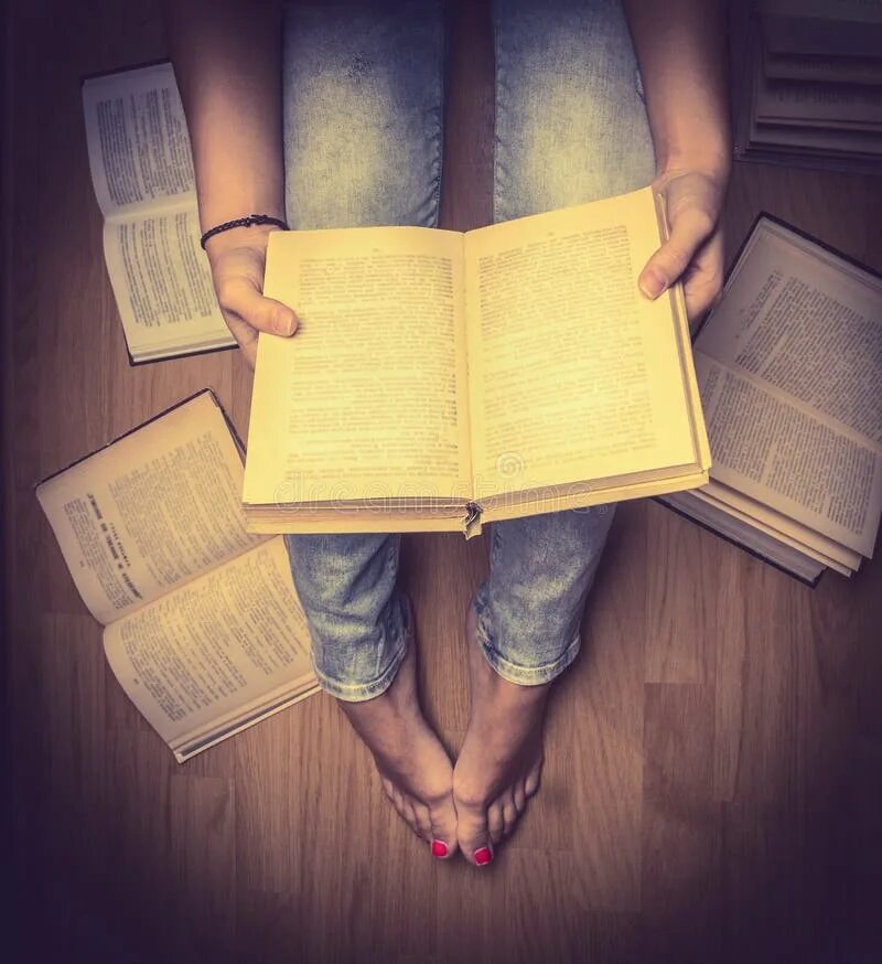 На столе лежит книга которая отражается. Девушка с книгой. Девушка с книгой сверху. Девушка с книгой на коленях. Девочка с книжкой на коленках.