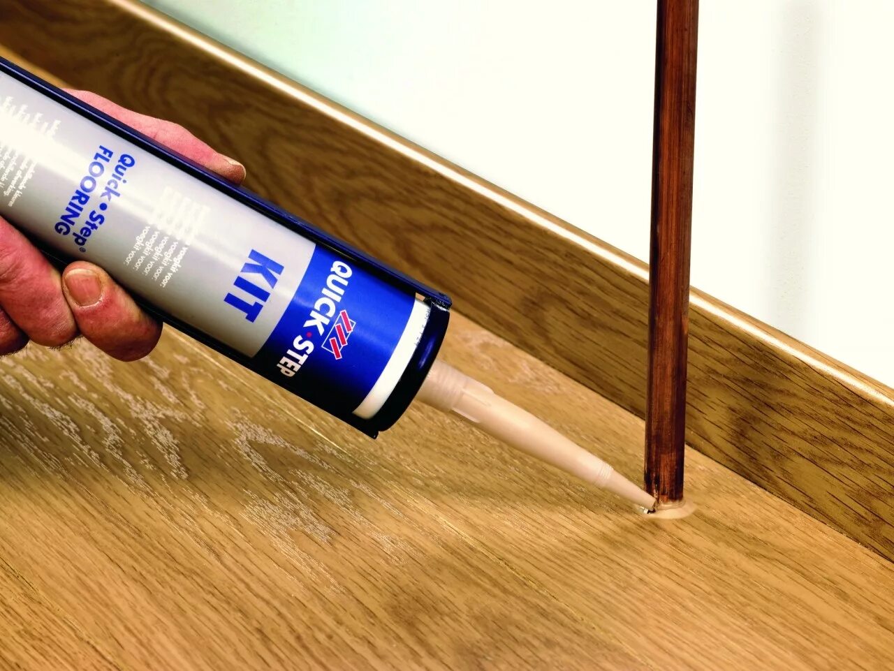 Герметик для щелей в ламинате. Герметик стыка паркета и плитки sika. Замазать стыки ламината. Заплатка на ламинат. Щель между плинтусом и полом.