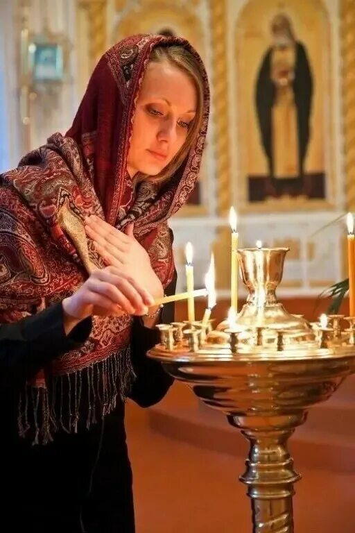 Ставит свечку девушке