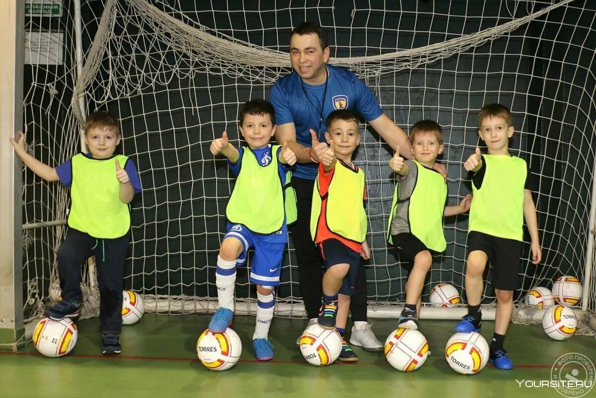 Детский тренер по футболу. Тренер по футболу для детей. Детский тренер. Тренер по футболу для детей. Футбольный мяч на траве.