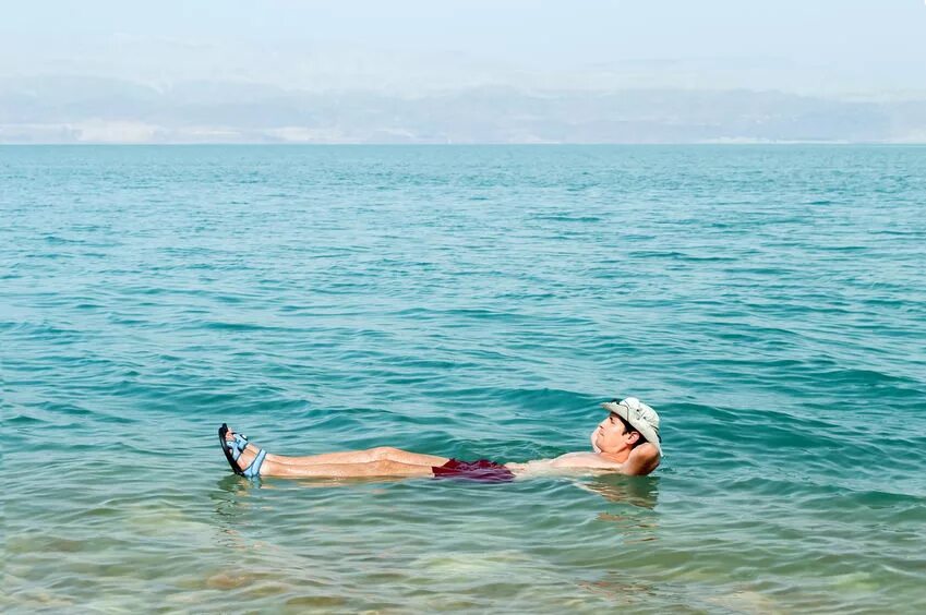 Мертвое море человек на воде. Мертвое море плавать. Мёртвое море люди купаются. Мертвое море люди плавают. Человек лежит в воде.