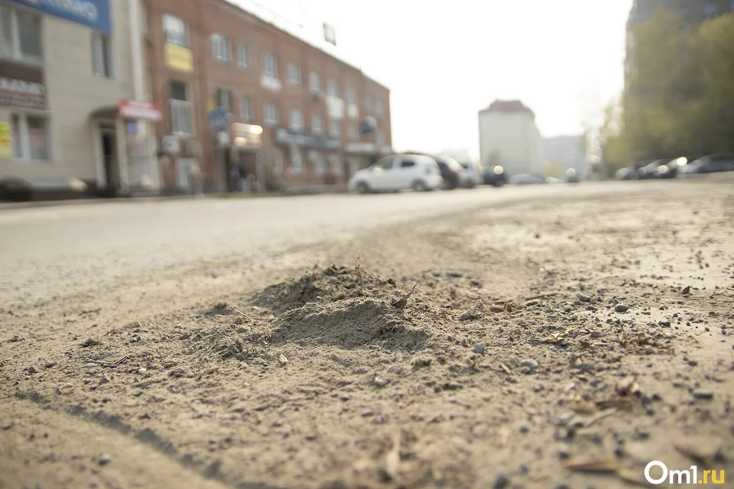 Легкая пыль несется по дороге далеко. Новосибирск в грязи и пыли. Пыль. Дорожная пыль. Пыль на дороге.