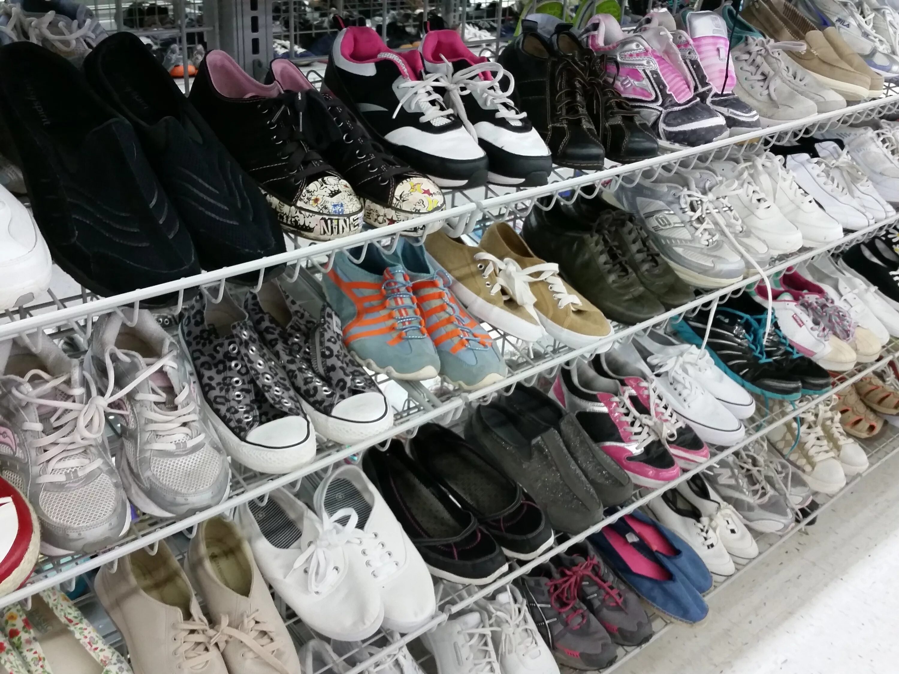 Базар обуви. Рынок обуви. Кроссовки на прилавке. Витрина с обувью на рынке.