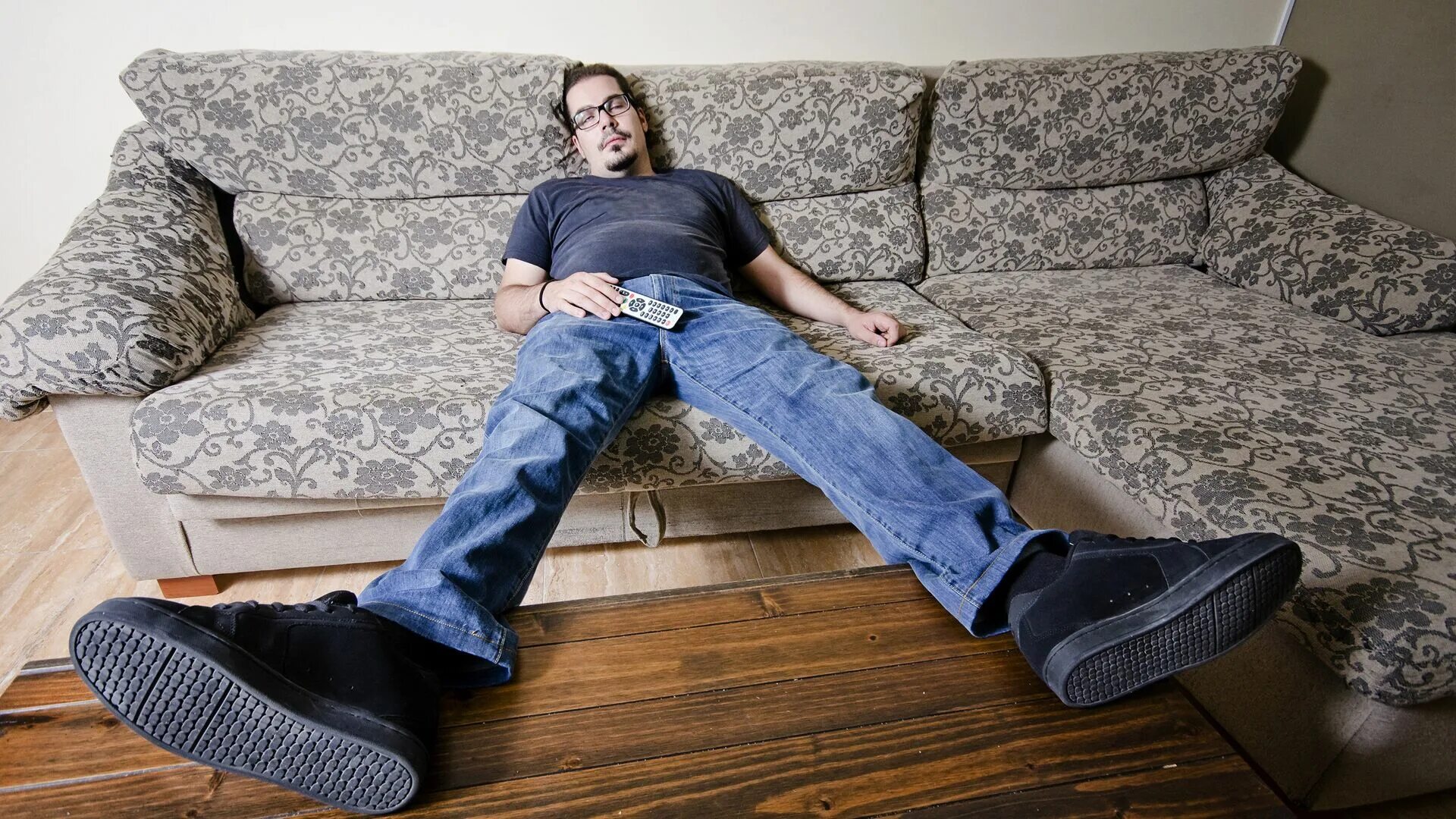 Пассивный мужик. Отдыхает на диване. Мужчина на диване. Человек сидит на диване. Мужик отдыхает на диване.