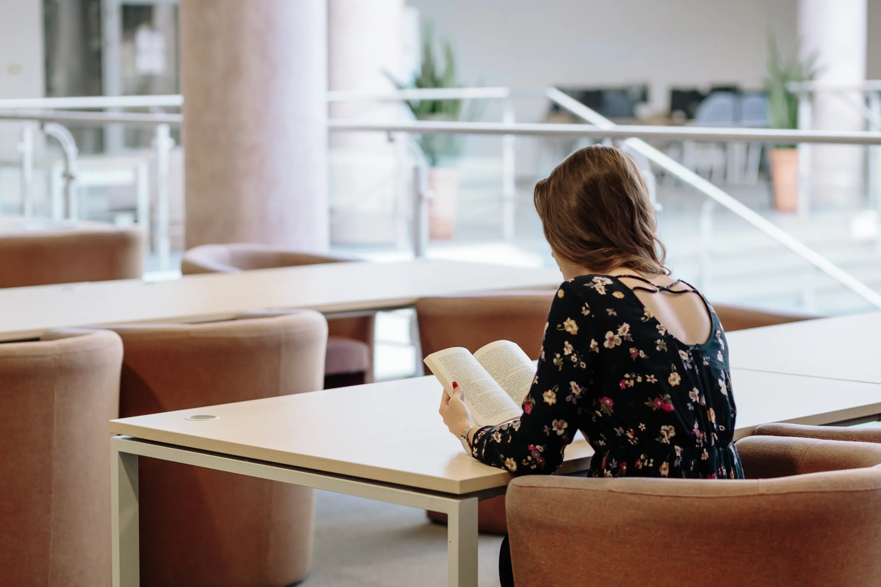 She is sitting at the table. Девушка читает. Девушка читает книгу. Бизнес женщина. Девушка читает в кафе.