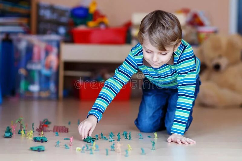 Мальчик играет на полу. Дети играют в солдатиков. Ребенок играется с солдатиками. Мальчик играет в солдатиков. Солдатики для детей.