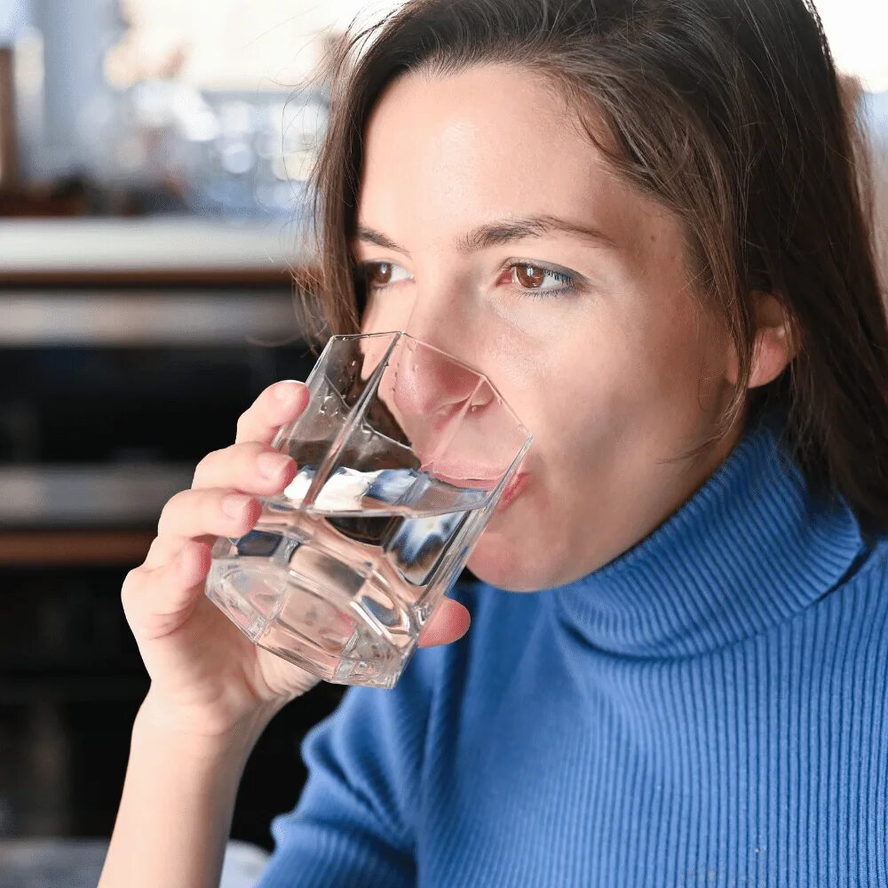 Женщина пьет воду. Женщина пьет из стакана. Женщина пьет воду из стакана. Женщина пьет из стаканчика.