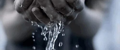 Рука из воды. Текучие воды. Вода стекает с рук. Струйка воды. Каплями дождя смывает след