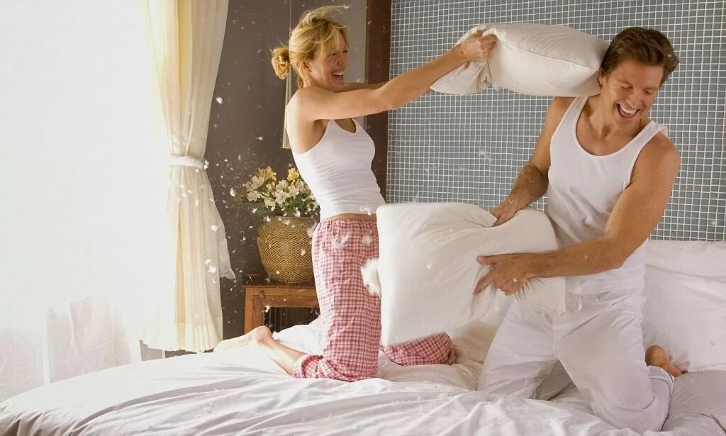 Постельное воняет. Постельное белье с женщиной. Застеленная кровать. Пара на подушке. Дерутся подушками.