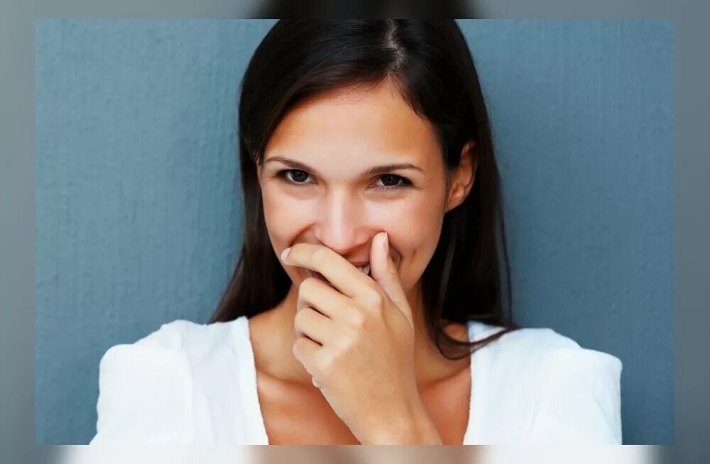 Девушка прикрывает лицо рукой. Женщина стесняется. Немного стесняется. Немного стесняется. Девушка прикрывает рот ладонью.