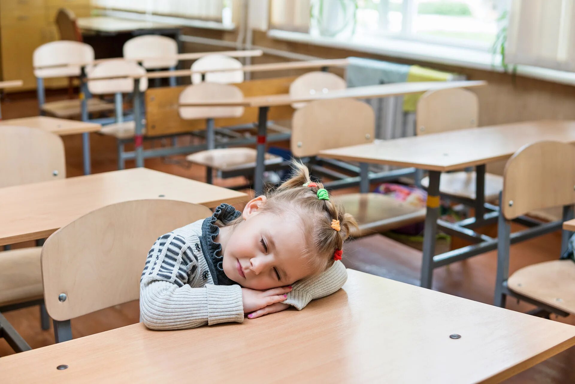 Дети спят в школе. Девочка первоклассница сидит за партой в школе. Школьник уснул на парте.