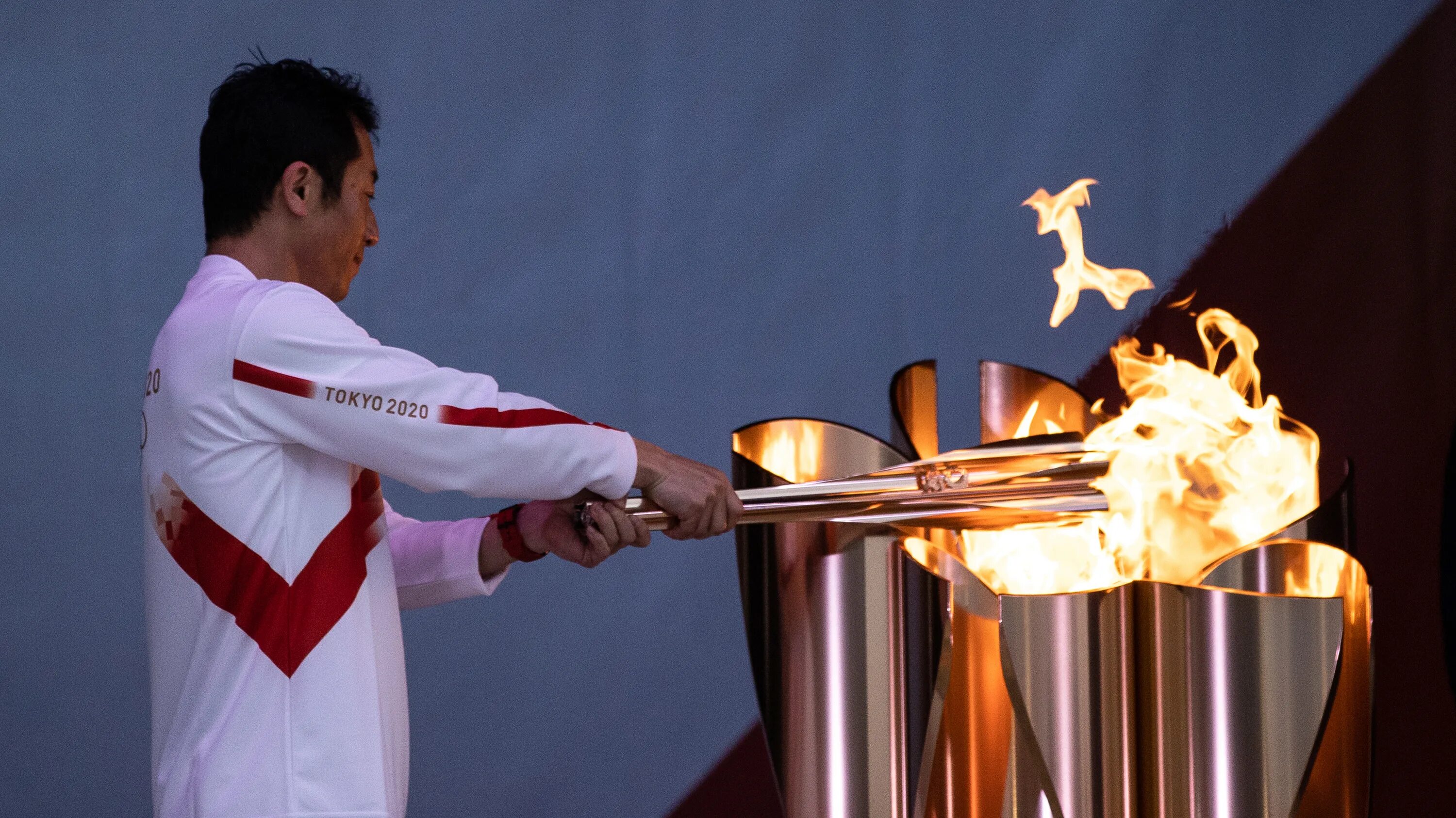 Факел современного огня современных игр зажигается. Факел Олимпийских игр. Олимпийский огонь стрелой. Олимпийский огонь фон.
