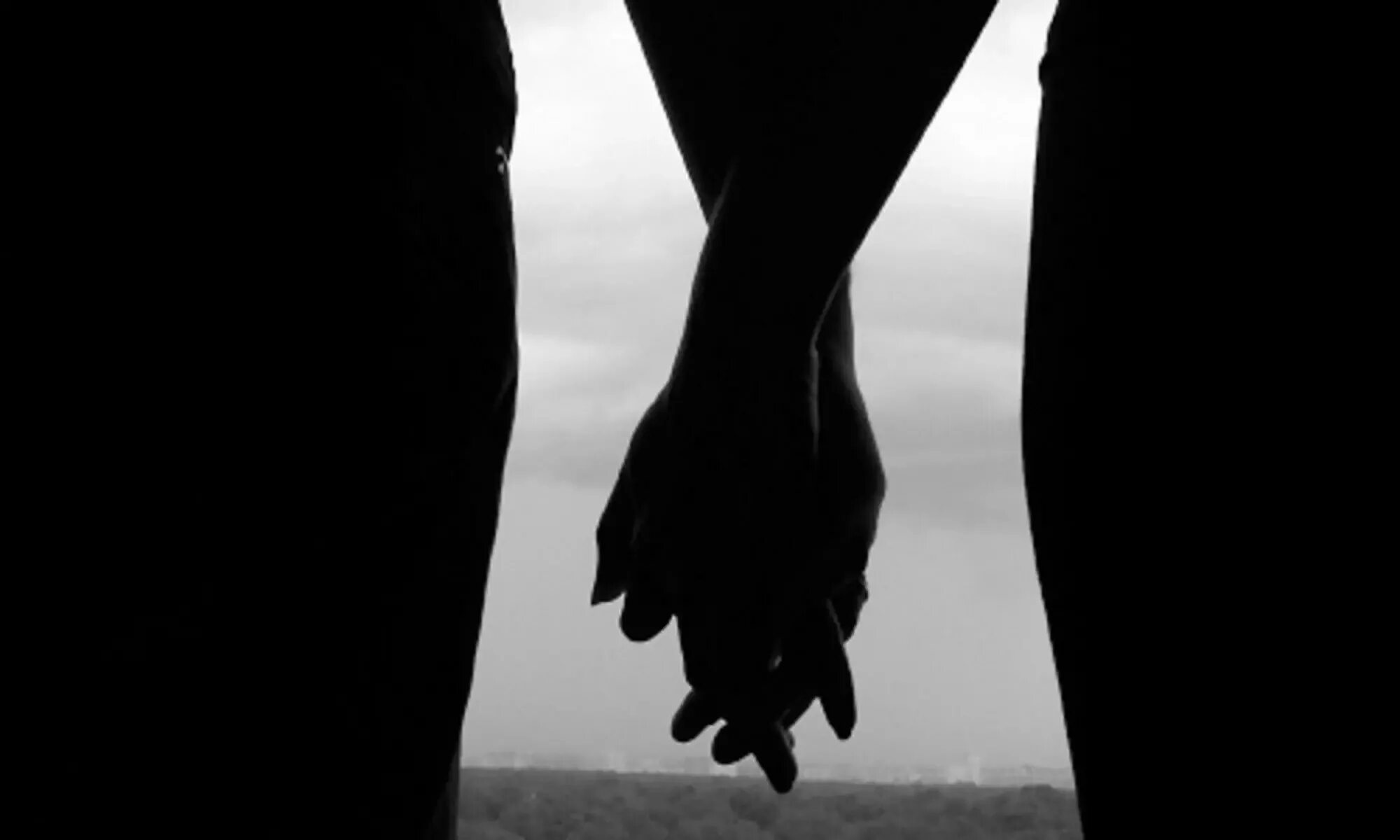 Держаться в тени. Рука в руке. Руки мужчины и женщины. Парень и девушка держатся за руки. Взявшись за руки в темноте.