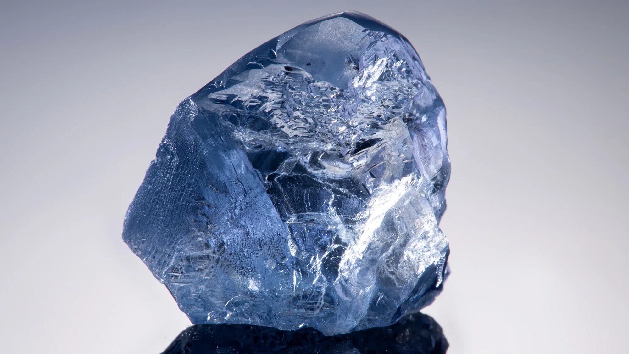 Алмаз бром. Голубой Алмаз Тавернье. Алмаз Кристалл неограненный. Голубой Алмаз камень необработанный. Неограненный синий Алмаз.