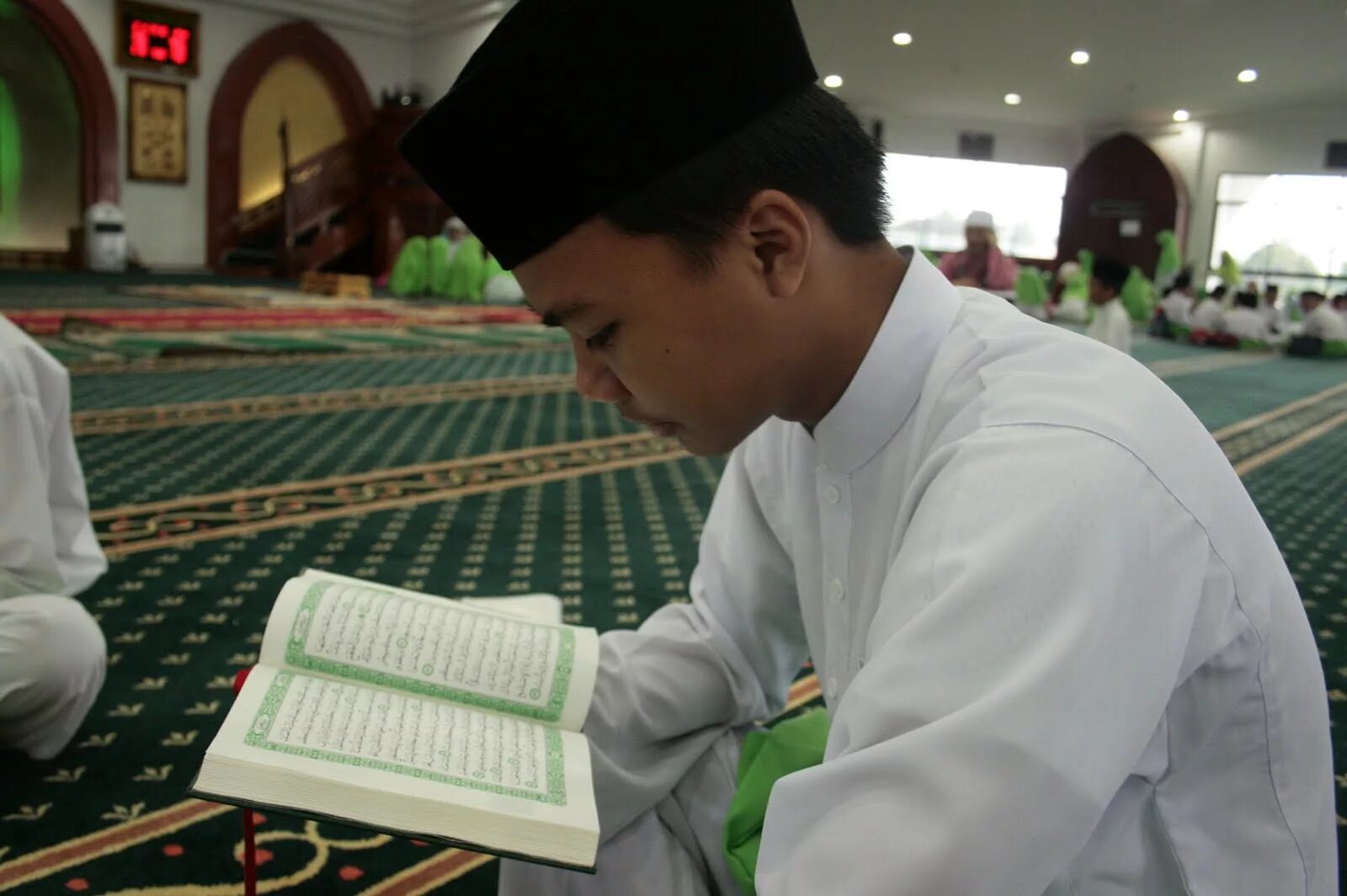 Коран. Чтение Корана. Открытый Коран в руках. Коран фото.