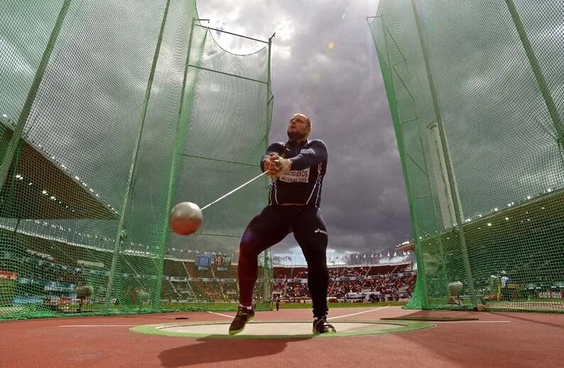 Метание молота выполняется из круга отгороженного сеткой. Hammer throw. метание молота. спорт метание молота. метатель ядра.