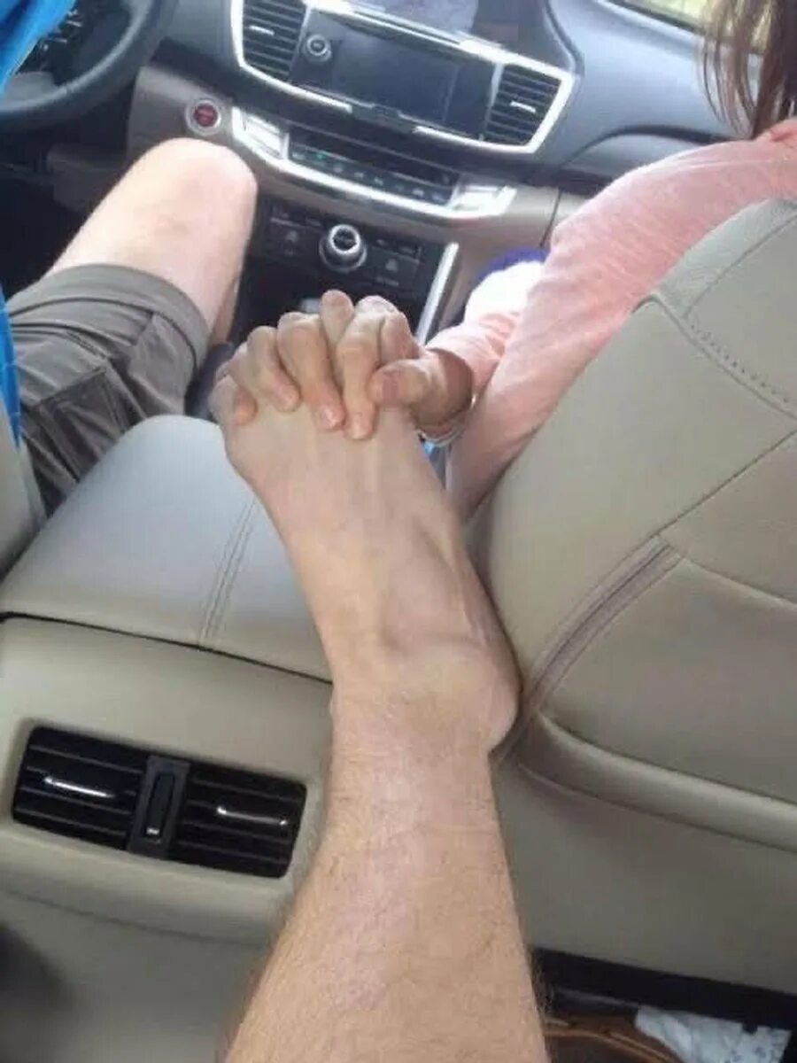Рука в руке в машине. Держаться за руки в машине. Ноги парней. Держась за руки в машине.
