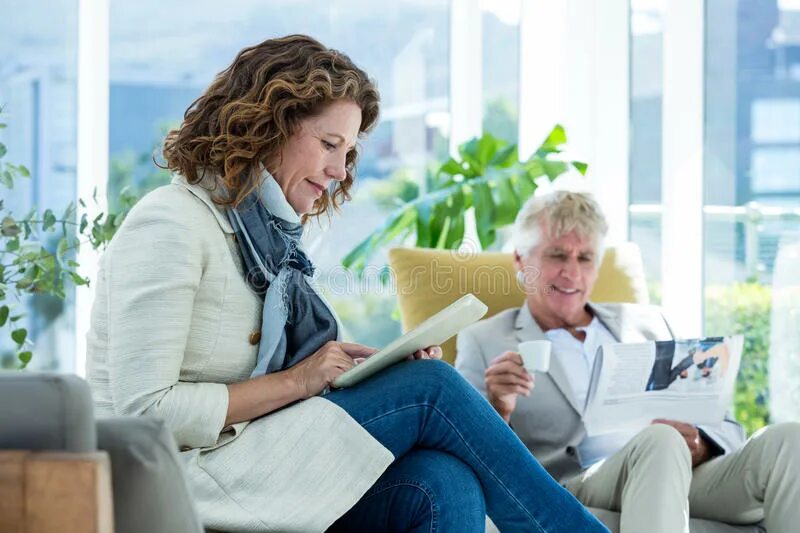 Woman using man. Woman reading a newspaper.