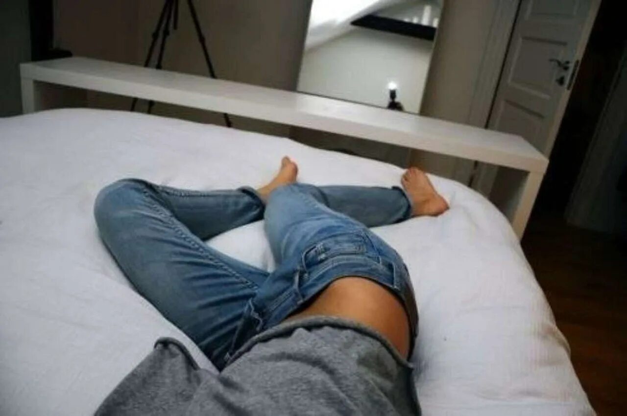 Ноги парней. Мужские ноги на кровати. Ноги в джинсах. Парень в кровати.