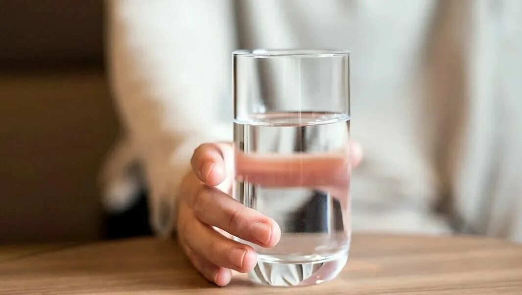 Прием стакан воды. Стакан воды. Стакан воды на столе. Стакан воды в руке. Держит стакан с водой.