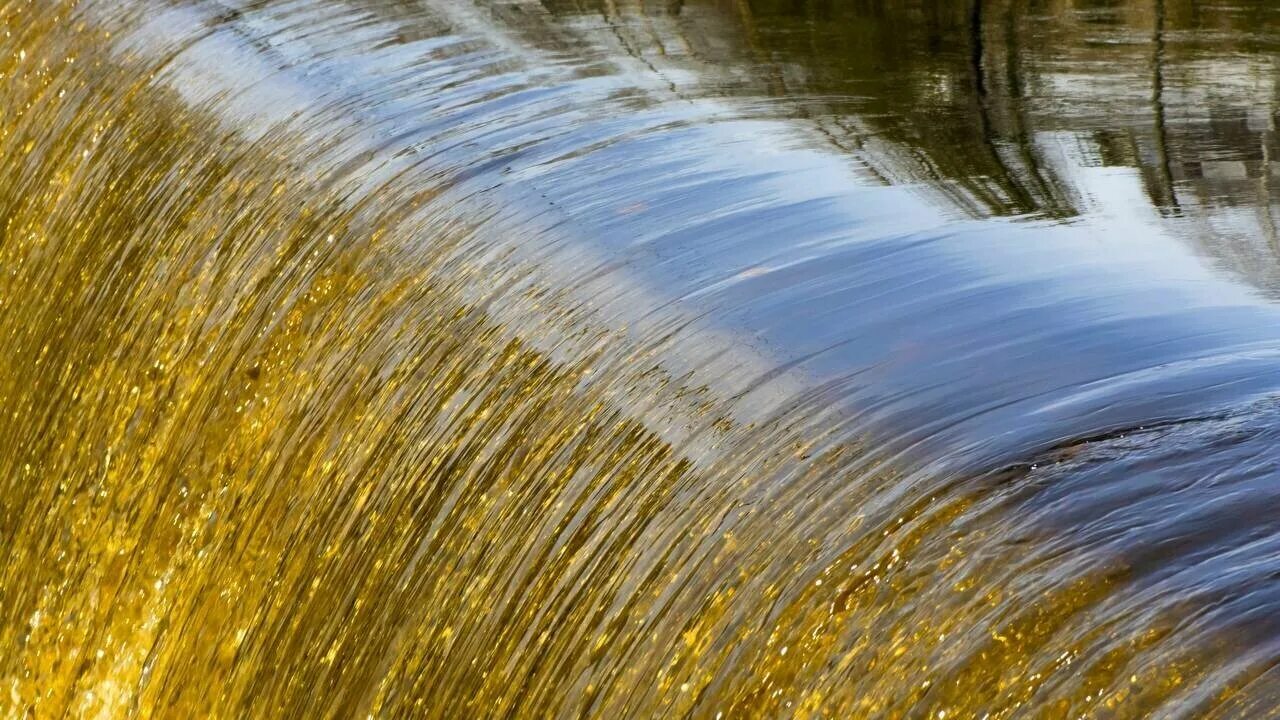 Поток воды. Красивая блестящая вода. Водопад. Поток водопада.