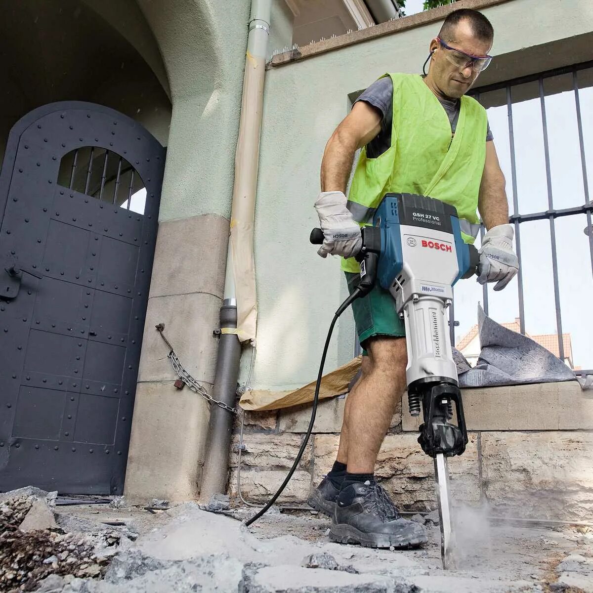 Демонтаж бетонной стены. Строитель с перфоратором. Отделочные работы. Демонтаж перегородок. Демонтажные работы оборудования.