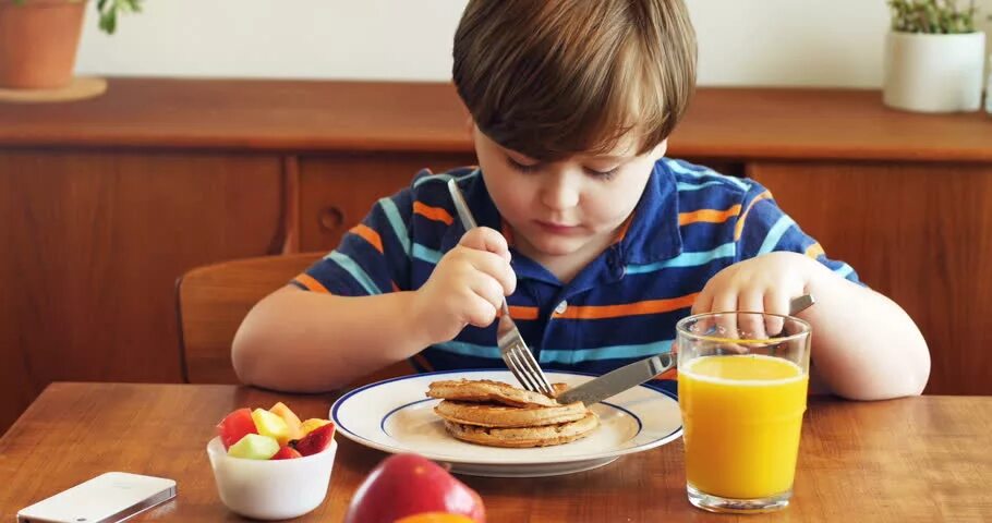 Ребенок завтракает. Мальчик завтракает. Школьник за завтраком. Утренний завтрак школьника.