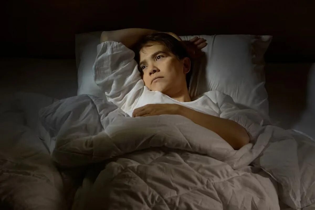 Почему женщины потеют ночью во время сна. Инсомния актриса. Лежит на кровати. Про сон.
