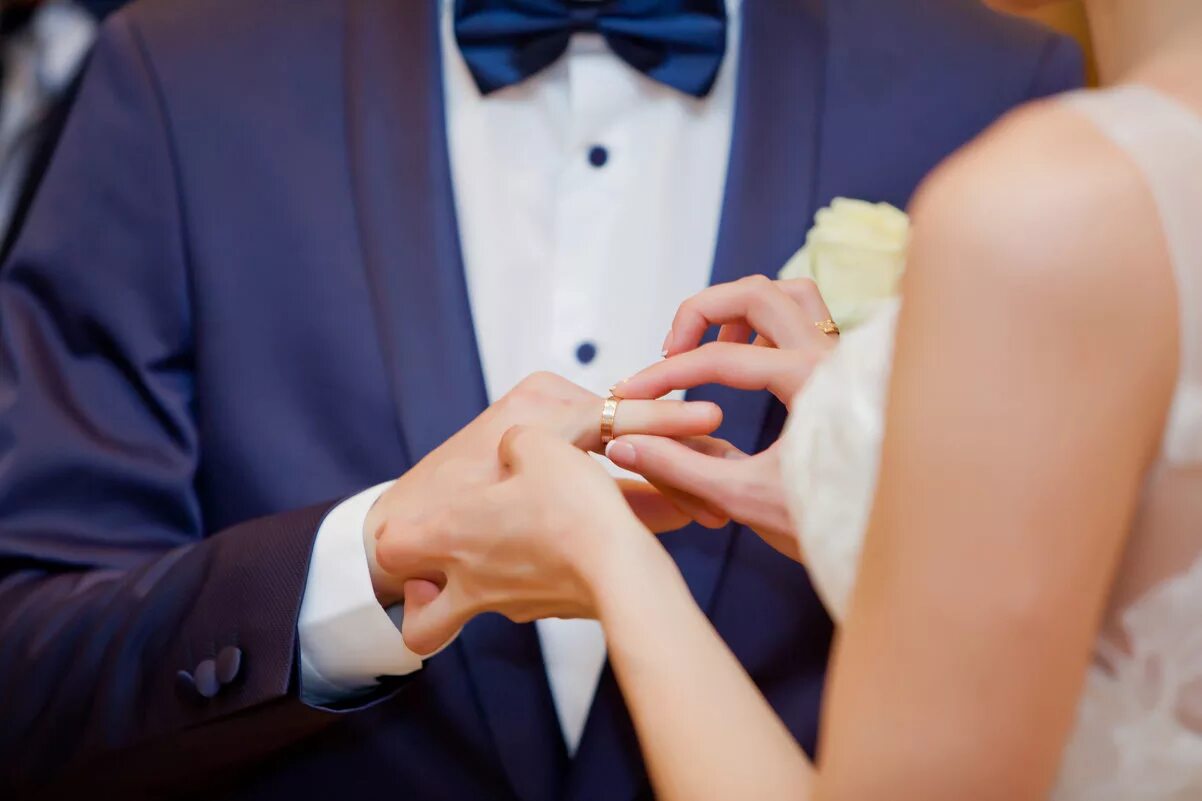 Замуж на какую руку кольцо. Жених надевает кольцо. Надевает кольцо невесте. Свадьба жених надевает кольцо. Невеста на руках у жениха.