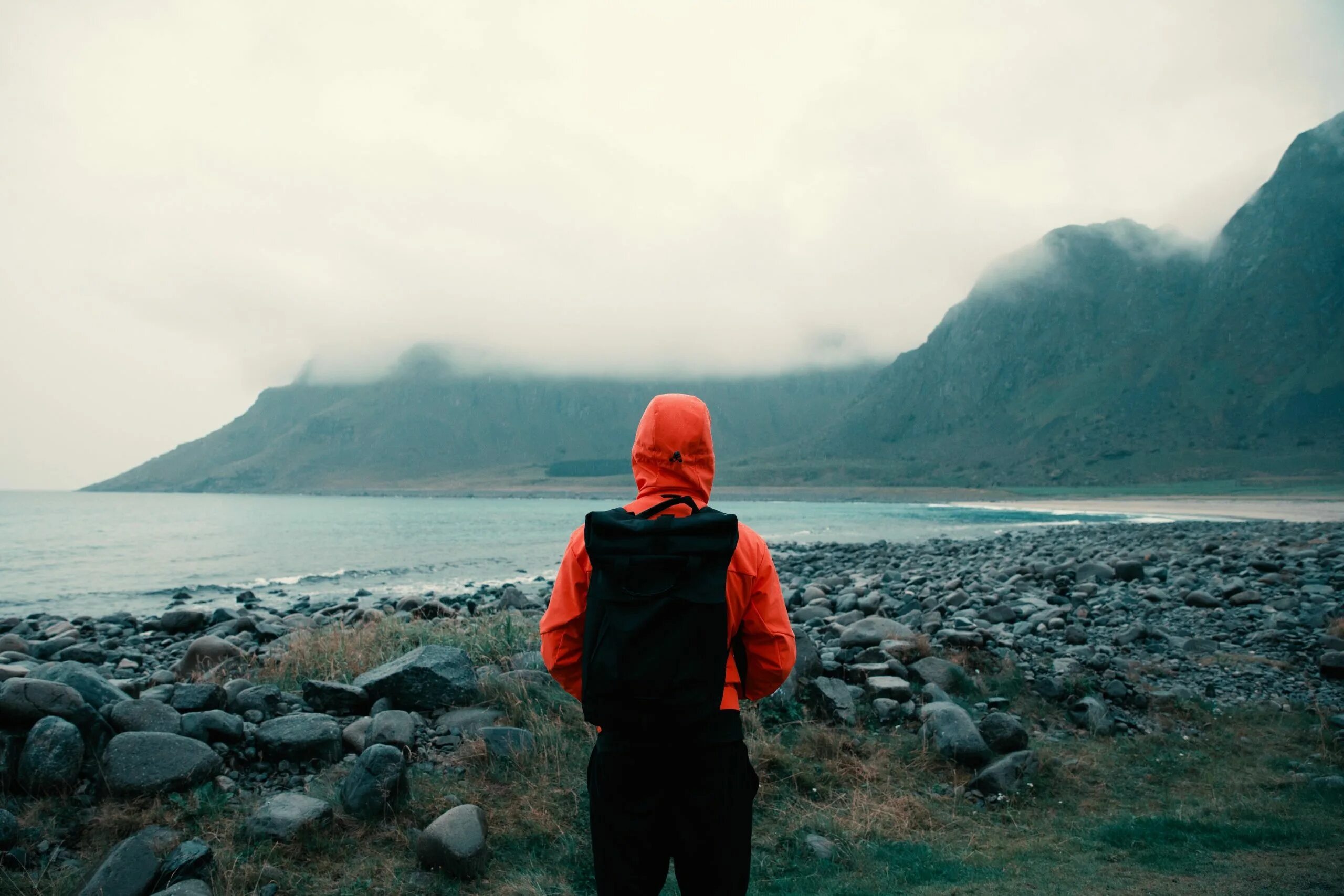 Rain travel. Путешествие и дождь. Человек в горах в оранжевой куртке. Travelling Unsplash. Coat with Mountains.