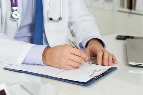 Врач выписывает рецепт на очки