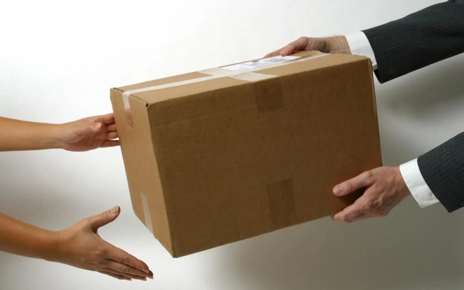 Человек получает посылку. Коробки в руках. Руки передают коробку. Передача товара. Передает коробочку в руки.