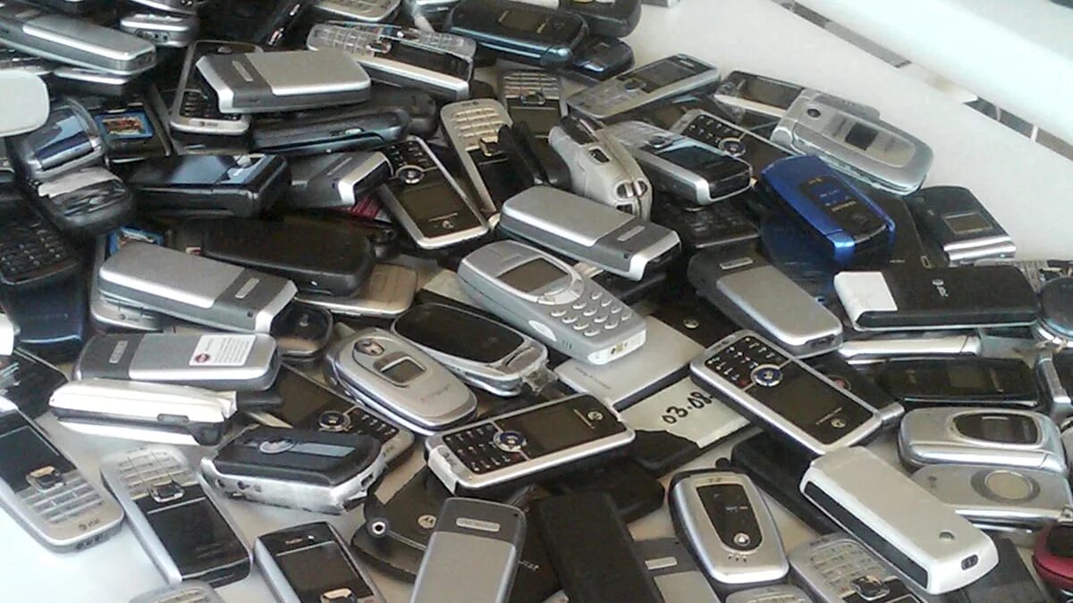 Много телефонов. Куча запчастей для телефонов. Много мобильных телефонов. Куча телефонов.