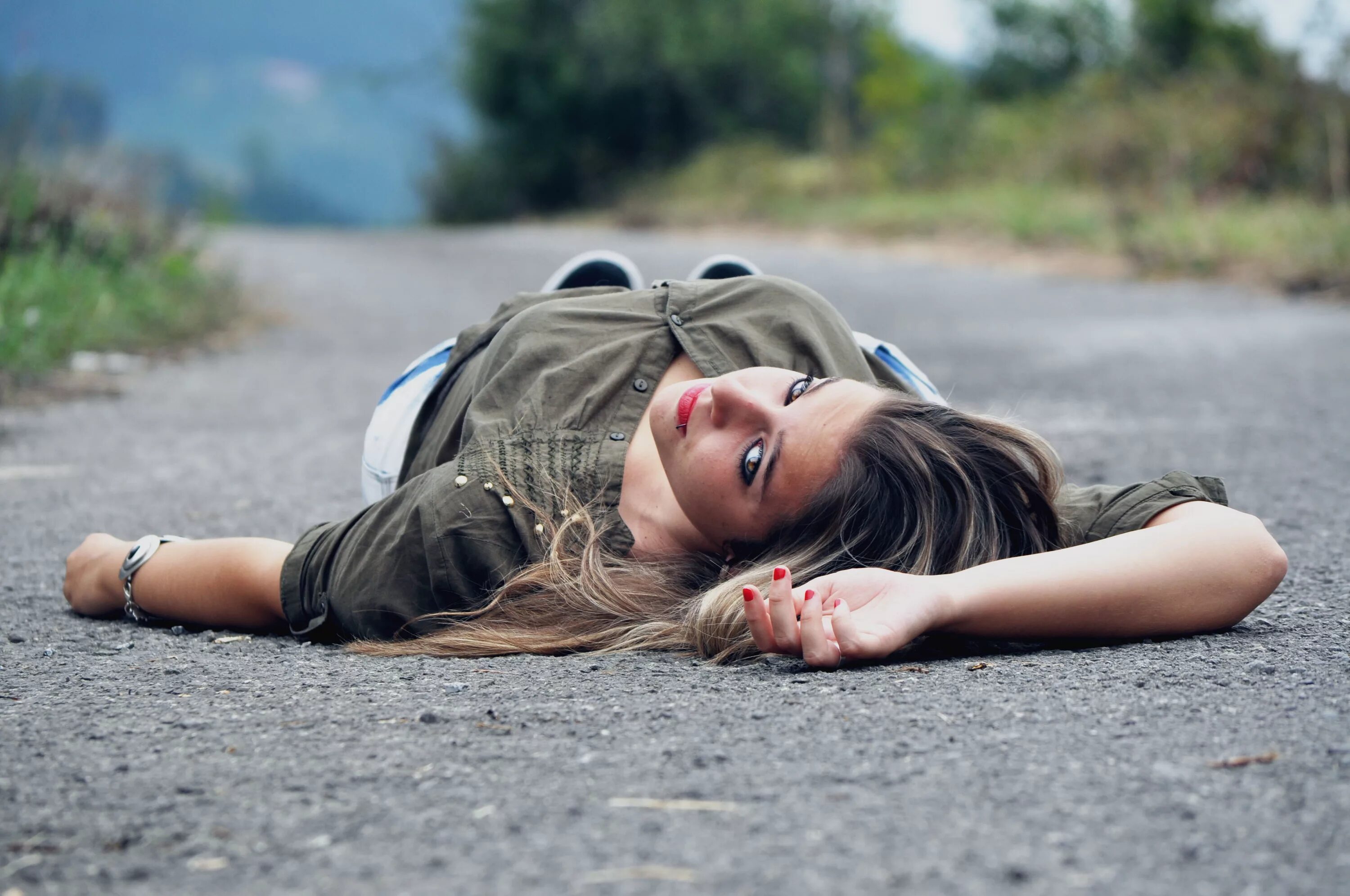 Девочка лежит на дороге. Девушка валяется на дороге. Девушка лежит на асфальте.
