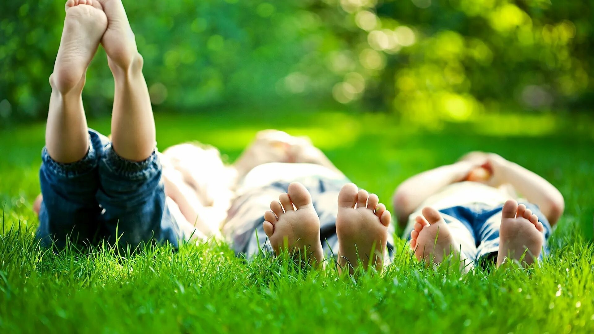 К вечеру на траве в саду. Лето дети. Лежит на траве. Дети и природа. Радостные люди на природе.
