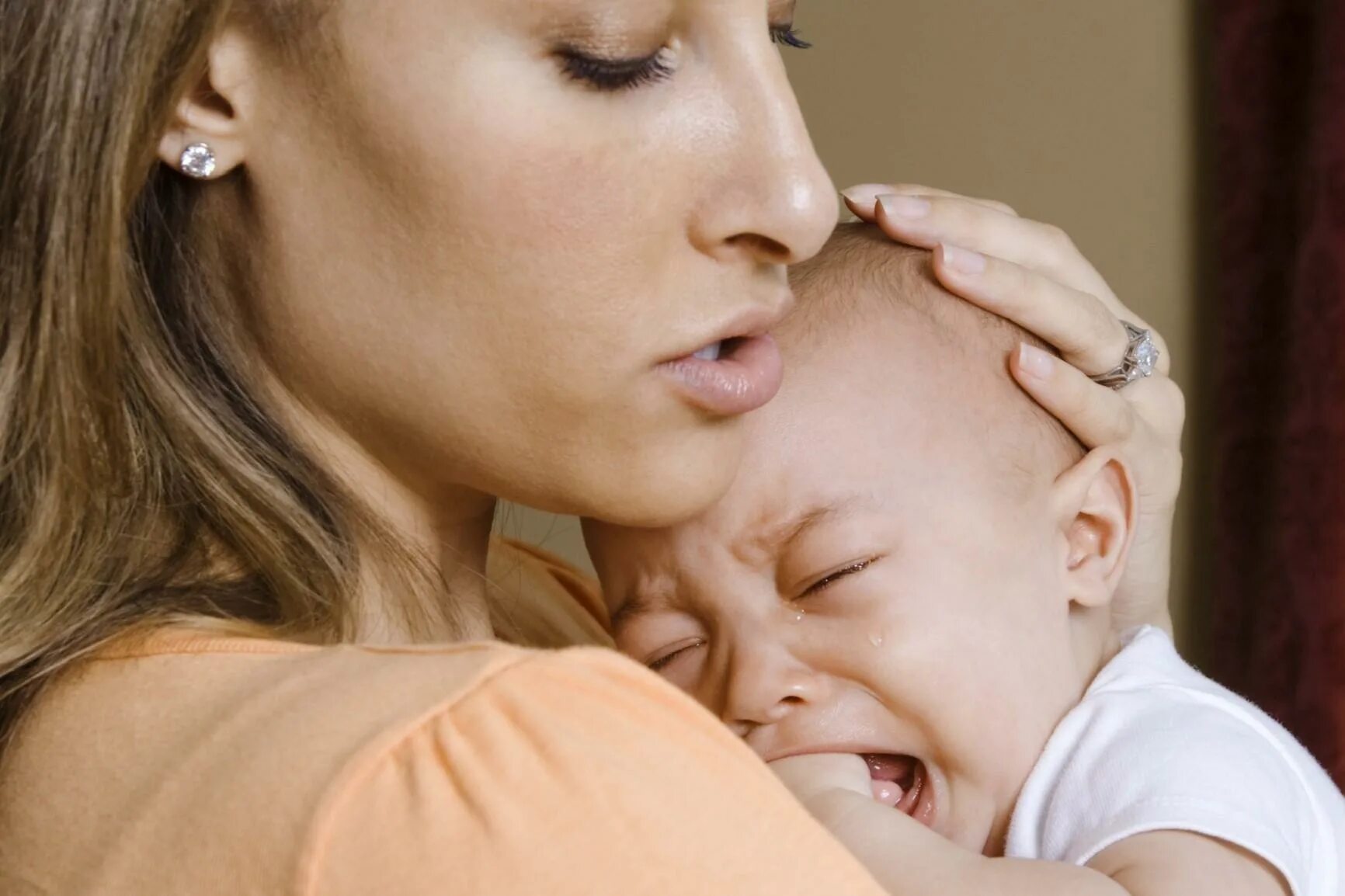 Ребенок плачет на груди. Мать с ребёнком на руках. Женщина с ребенком. Мама с плачущим ребенком. Мама успокаивает новорожденного.