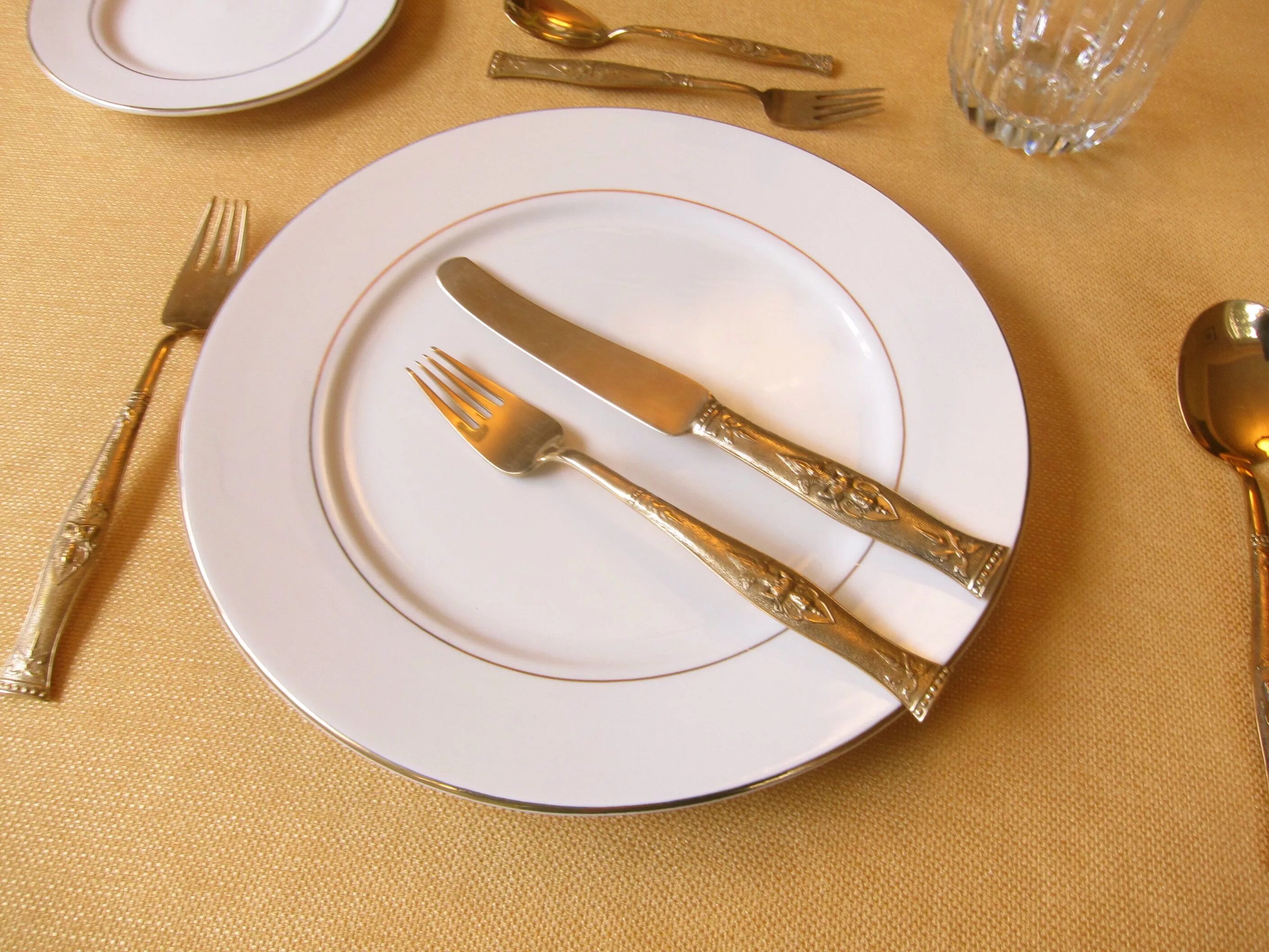 Как должны располагаться вилки ножи относительно тарелки. Сервировка столовых приборов. Столовые приборы на столе. Сервировка стола нож и вилка. Столовые приборы на тарелке.