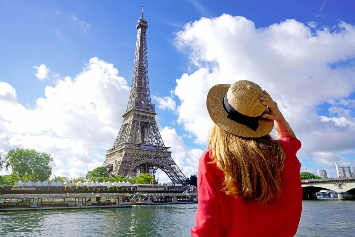 Туризм во Франции. Путешествие в Париж 2023. Девушка у Эйфелевой башни в Париже. Франция туристы общения.