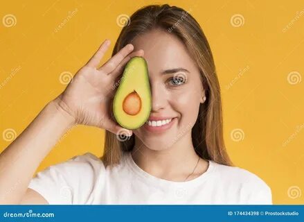 Happy Young Woman Holding Avocado Half, Covering Eye With Healthy Fruit Sto...