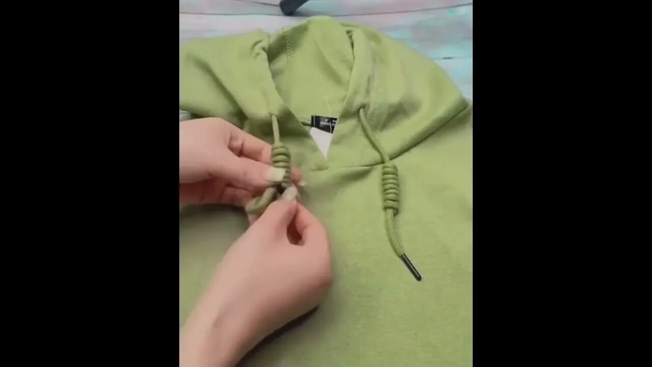 Красивые узелки на кофте. Узел для шнурка на капюшоне. Красивый узел на шнурках для толстовки. Завязка шнурков на толстовке. Как укоротить шнурки на толстовке.
